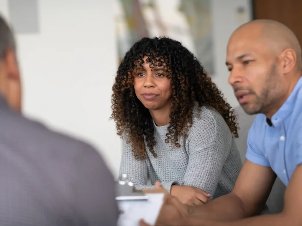 Couples-therapists-in-LA A couple sits in a therapy session with a professional, engaging in open and honest discussion, representing the supportive guidance offered by couples therapists in LA.