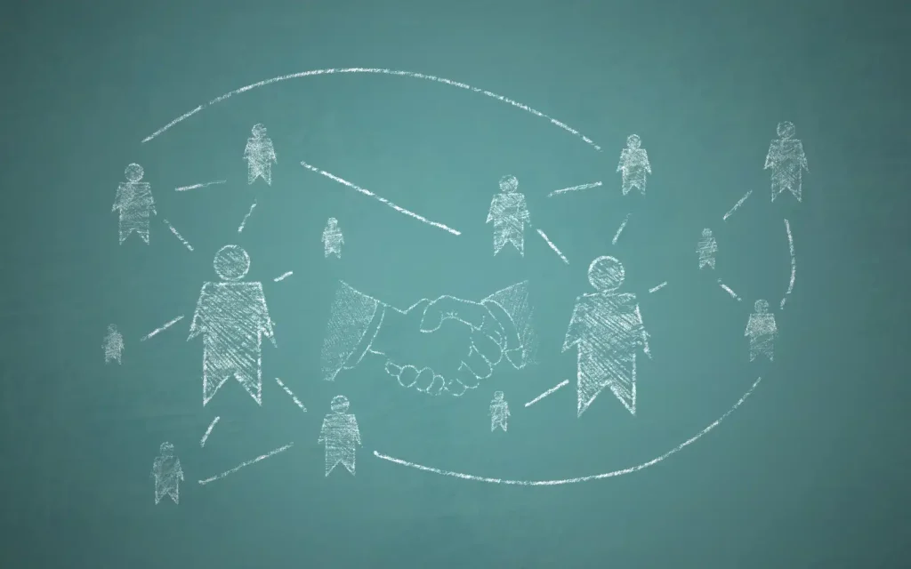 Attachment-theory-couples-therapy A chalkboard with hand drawn human figures on it with lines of connection between them symbolizing attachment theory in couple therapy