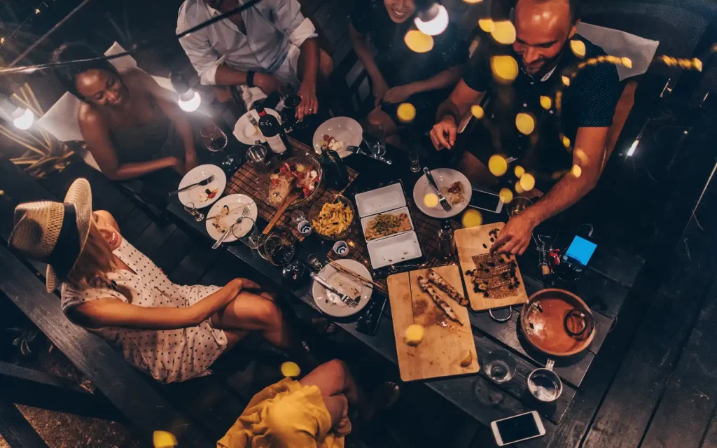 Healthy-boundaries-for-interracial-couples An interracial family eating dinner at a restaurant with an interracial couple discussing healthy boundaries at the table