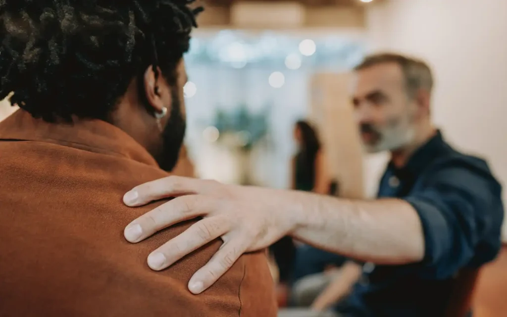 Interracial-couple-supporting-each-other An older man resting a supportive hand on his interracial partner's shoulder