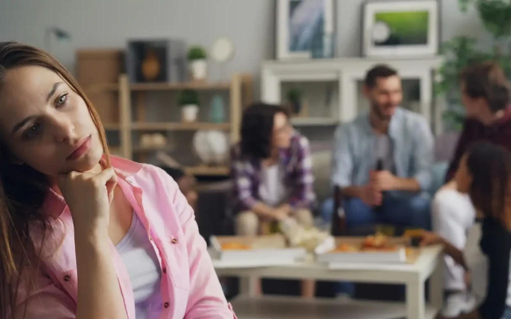Left-out-in-interracial-couple A woman sitting apart from a family group, representing how people can be left out of interracial family events due to language barriers