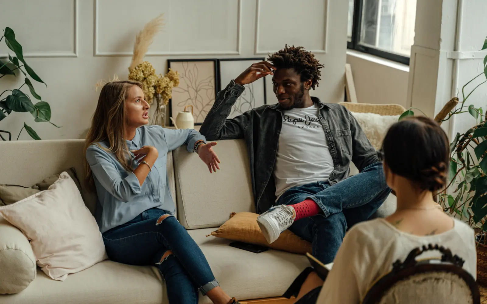 An interracial couple in couples therapy respectfully talking, representing emotional safety in a couples counseling session