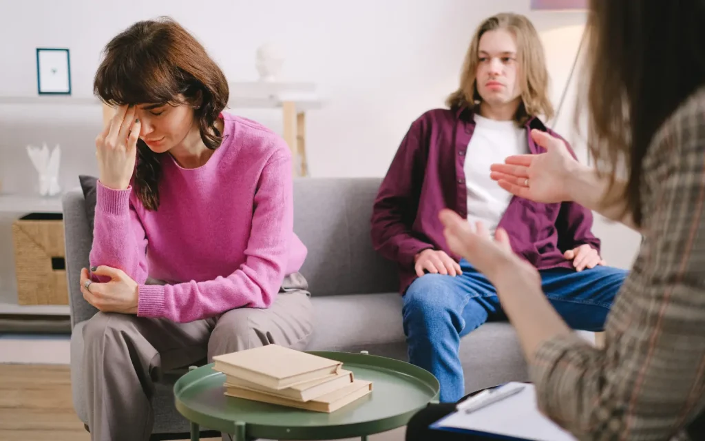 Couples-therapy-emotions A couple in a couples therapy session, the woman is crying and the man looks uncomfortable with the display of emotion