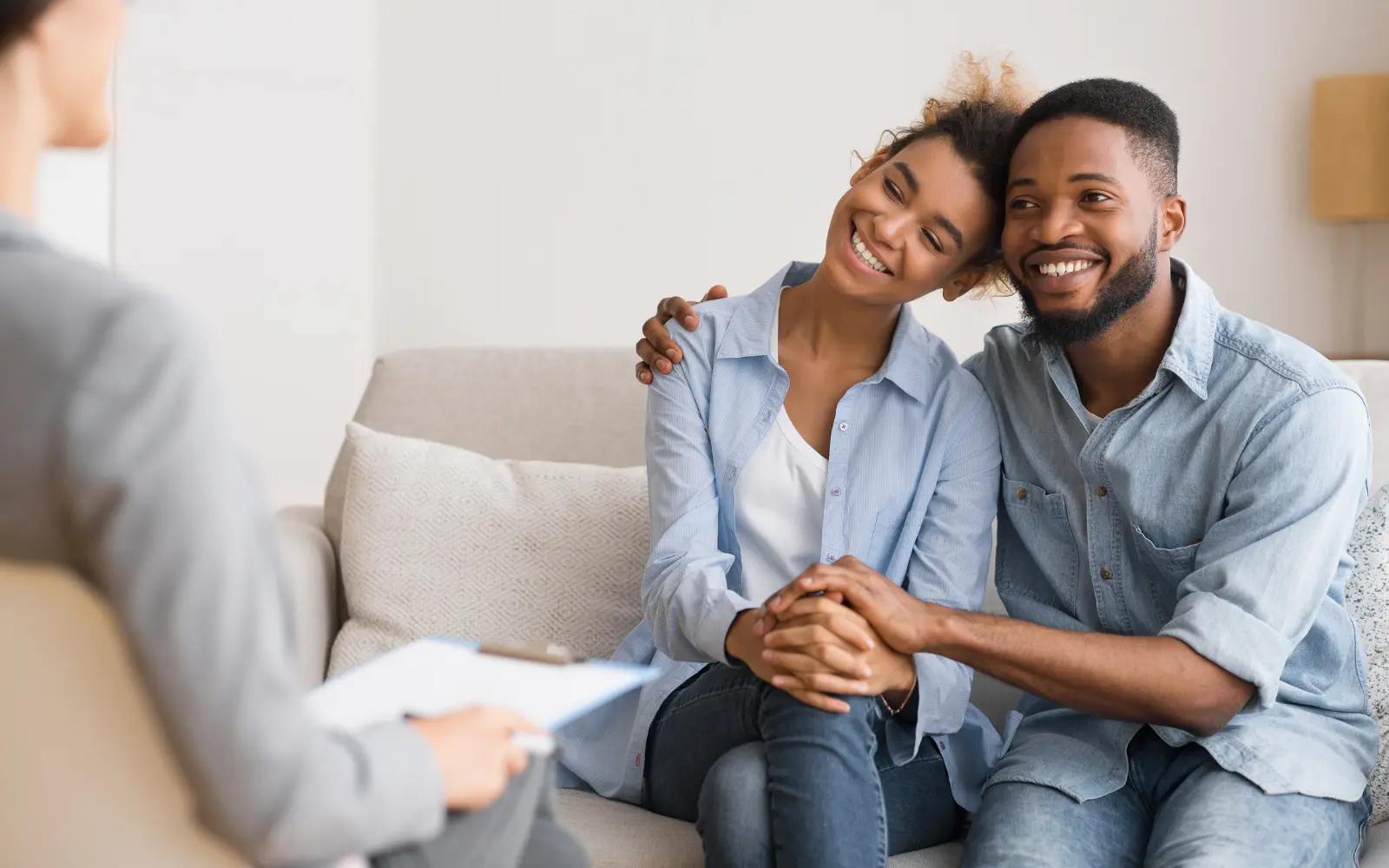 A black couple smiling and embracing during a pre-marital therapy session