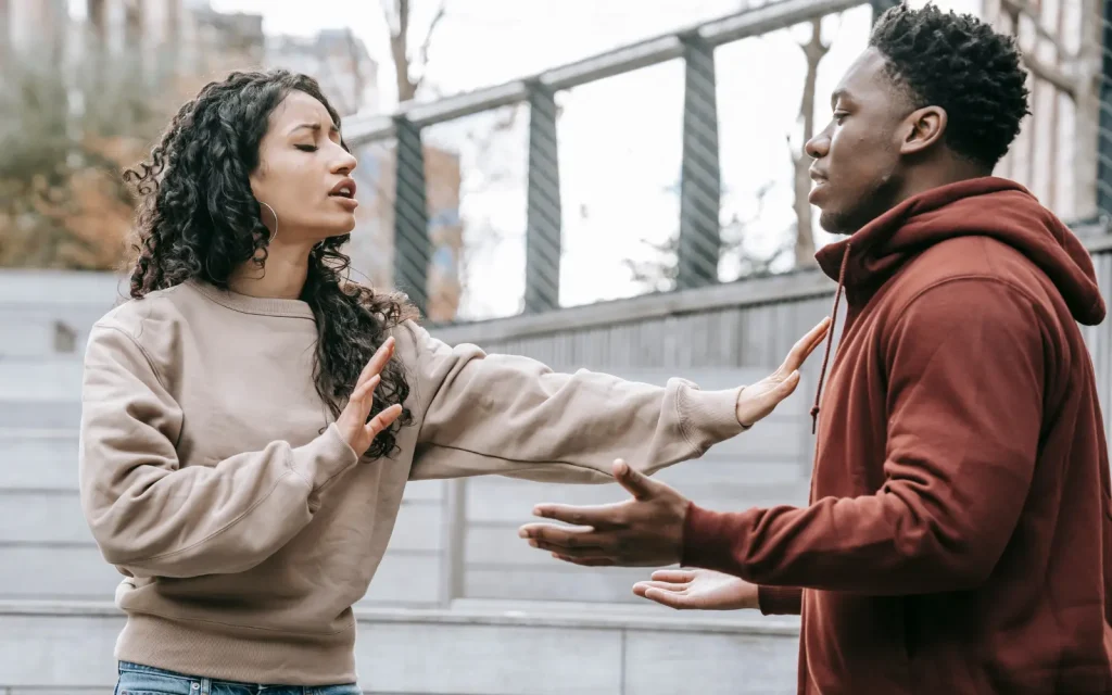 Abusive-relationships-in-couples-therapy A man and woman arguing outside in public, representing an abusive relationship