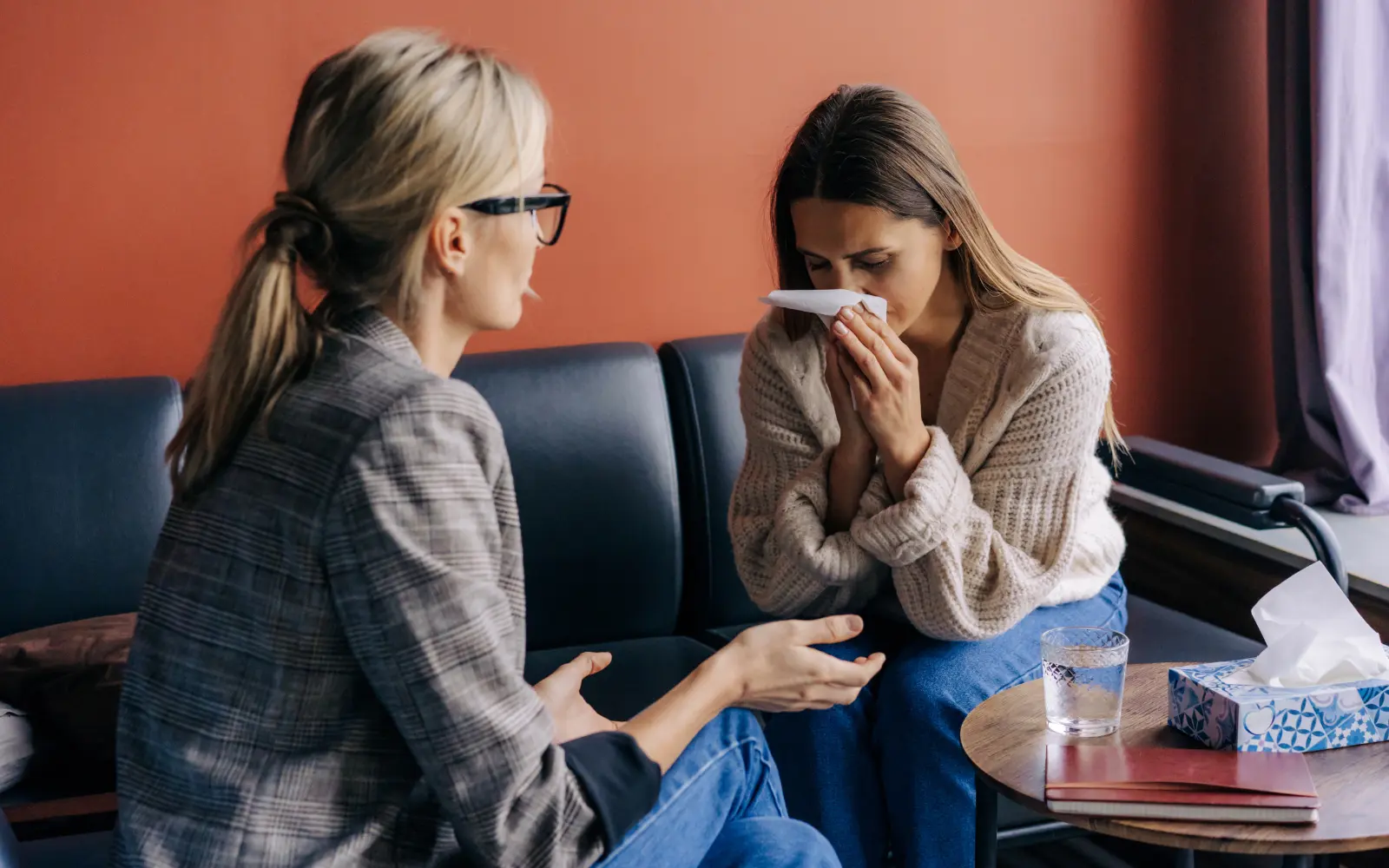 A woman crying on a therapist's couch, representing the emotional distress caused by relationship doubts.