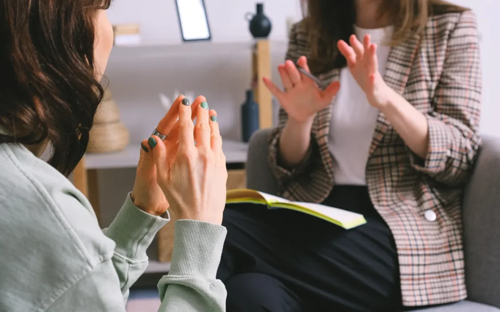 Emotional-attunement-in-therapy A therapist mirroring her client's hand movements, demonstrating unconscious emotional attunement