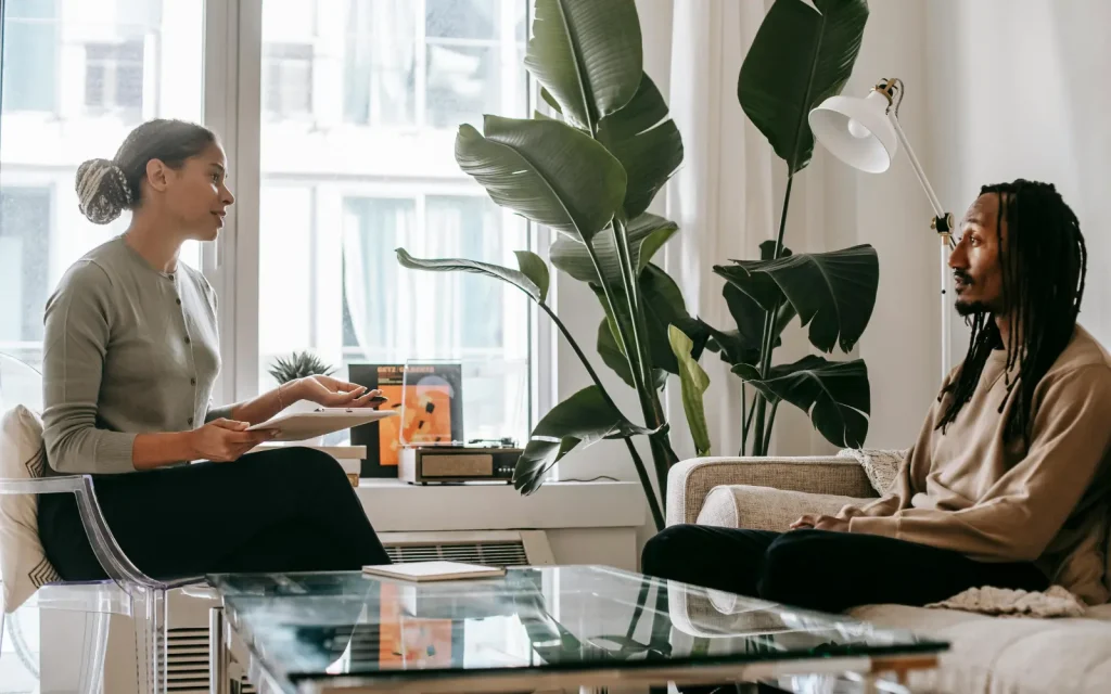 Individual-therapy-success A male client sitting on a therapist's couch, discussing the success of his individual therapy with his Los Angeles therapist