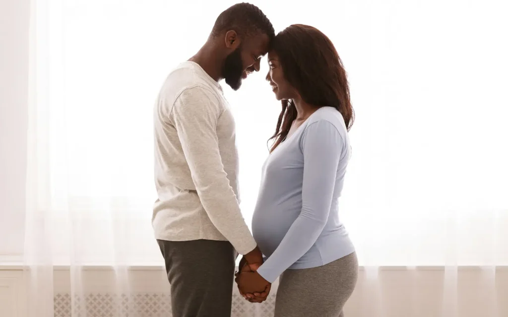 A neurodiverse black couple holding hands and looking into each other's eyes, representing the emotional bonding of neurodiverse couples counseling