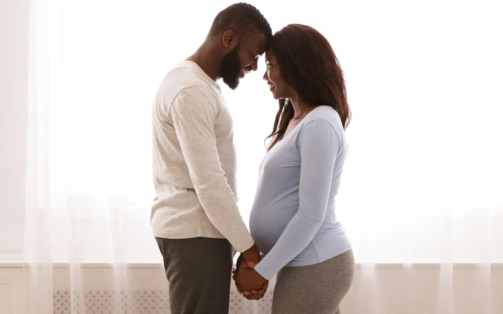 A neurodiverse black couple holding hands and looking into each others' eyes, representing the emotional bonding of neurodiverse couples counseling