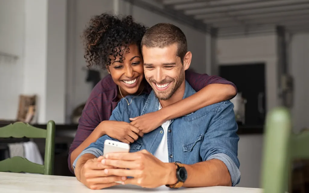 A neurodiverse couple smiling and embracing after working through their differences during couples therapy