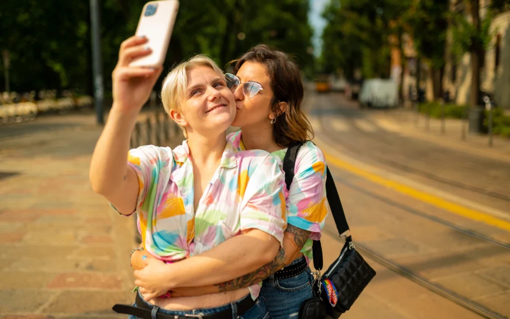 A lesbian neurodiverse couple embraces on a sidewalk