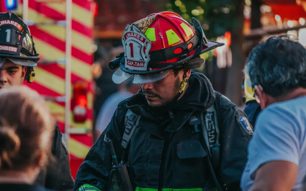 A fireman talking to distressed civilians, representing an appropriate time to park emotions and prevent yourself from crying