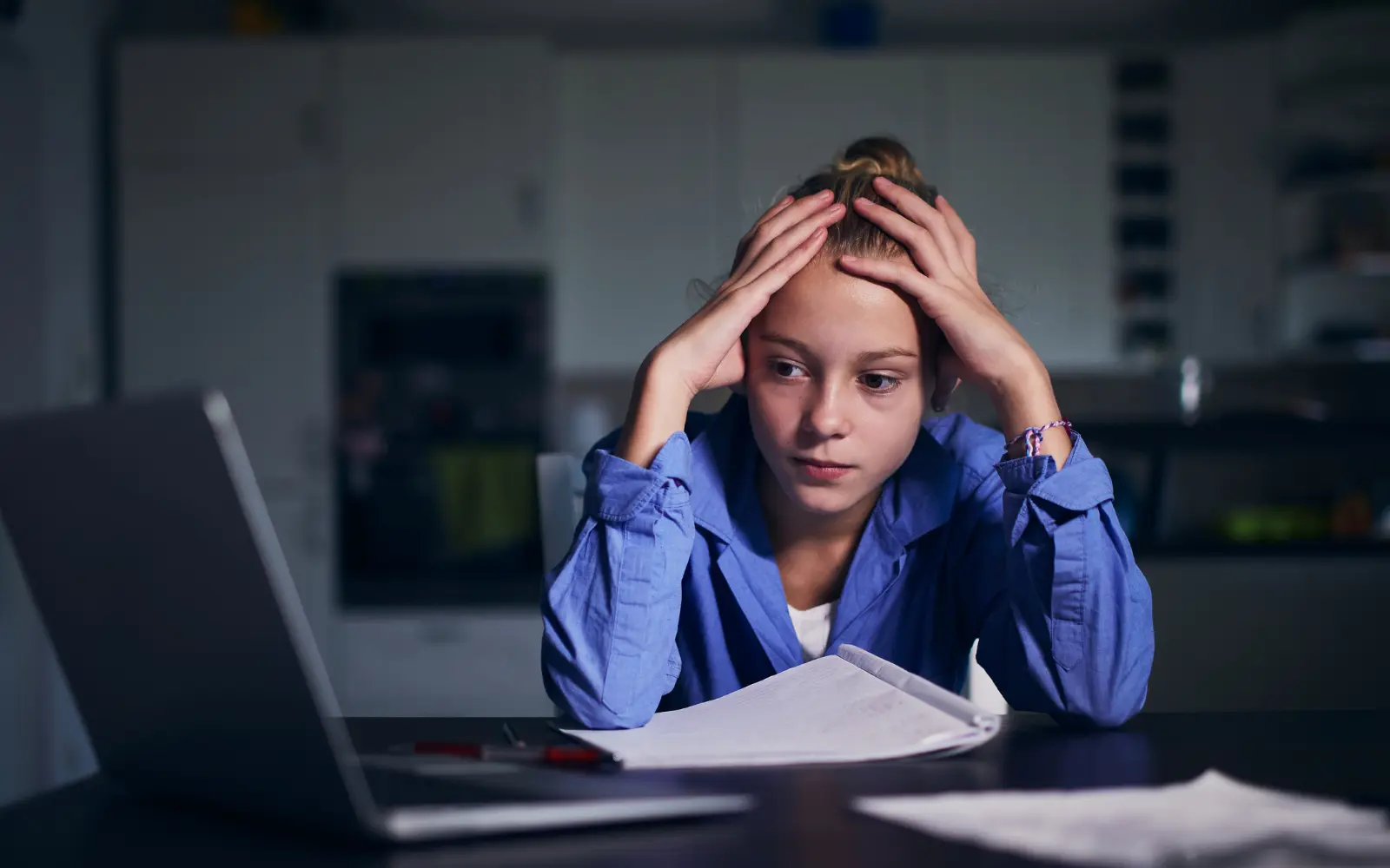 A child staring at a computer with her head in her hands, representing the importance of neuropsychological assessments for children in Los Angeles to help them succeed academically.