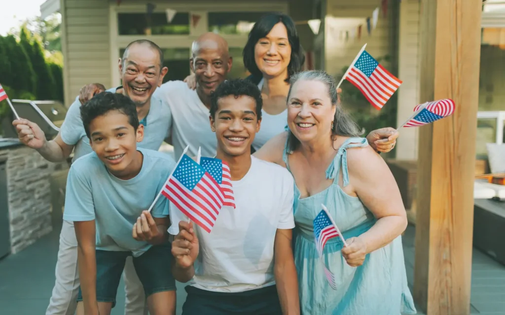 Asian-americans-and-neurodiversity A group of Asian Americans smiling and holding American flags, representing neurodiversity in Asian communities