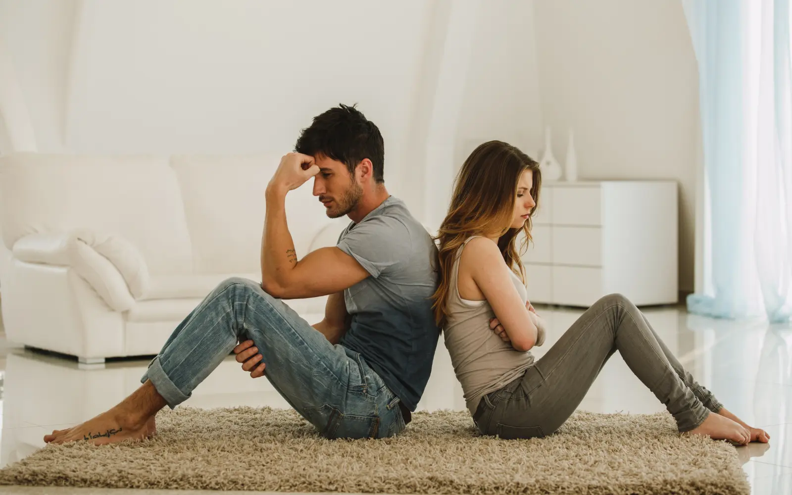 A couple sitting back to back, representing the impact of fighting in couples therapy