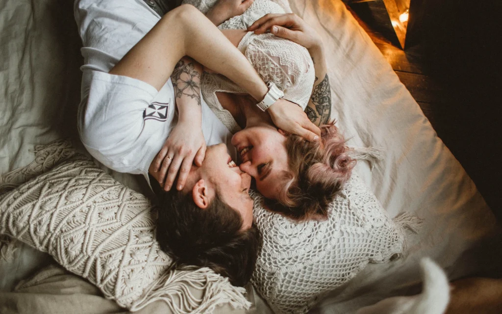 Happy-neurodiverse-couple-after-LA-couples-therapy A couple embracing on a bed, representing the impact of positive neuro-affirming couples therapy in LA