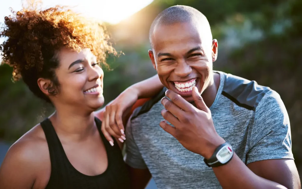 A black couple smiling and laughing with each other, demonstrating the positive impact of couples therapy on relationships