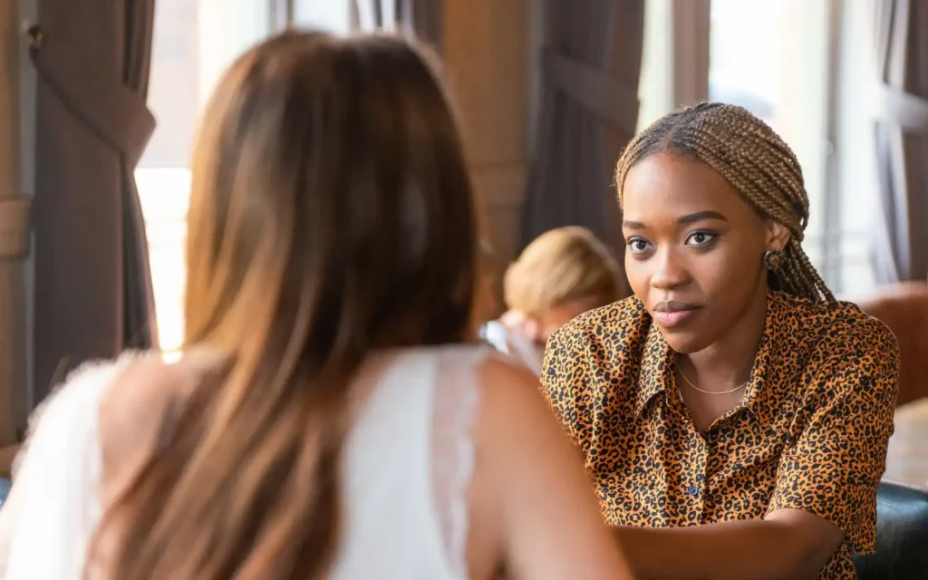 Professional-boundaries-in-Los-Angeles-therapy Two friends sitting across a table in a cafe, representing the importance of LA therapists setting professional boundaries