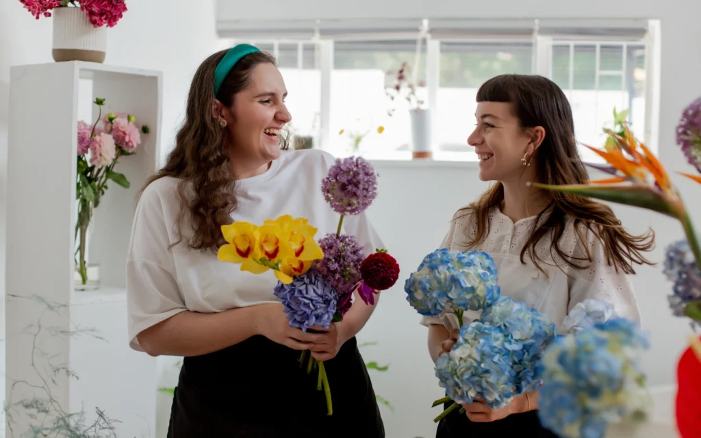 Therapy-in-LA-for-Autism-and-Neurodiversity A lesbian neurodivergent couple laughing and holding flowers, representing the impact of therapy for neurodiverse individuals in Los Angeles