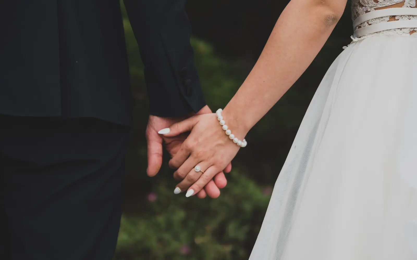 A married couple holding hands on their wedding day, representing marriage counseling in LA