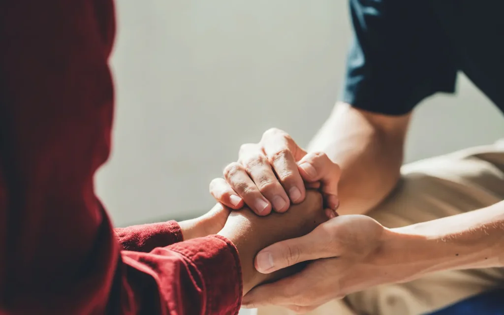 A couple holding hands in couples therapy, representing success in their treatment