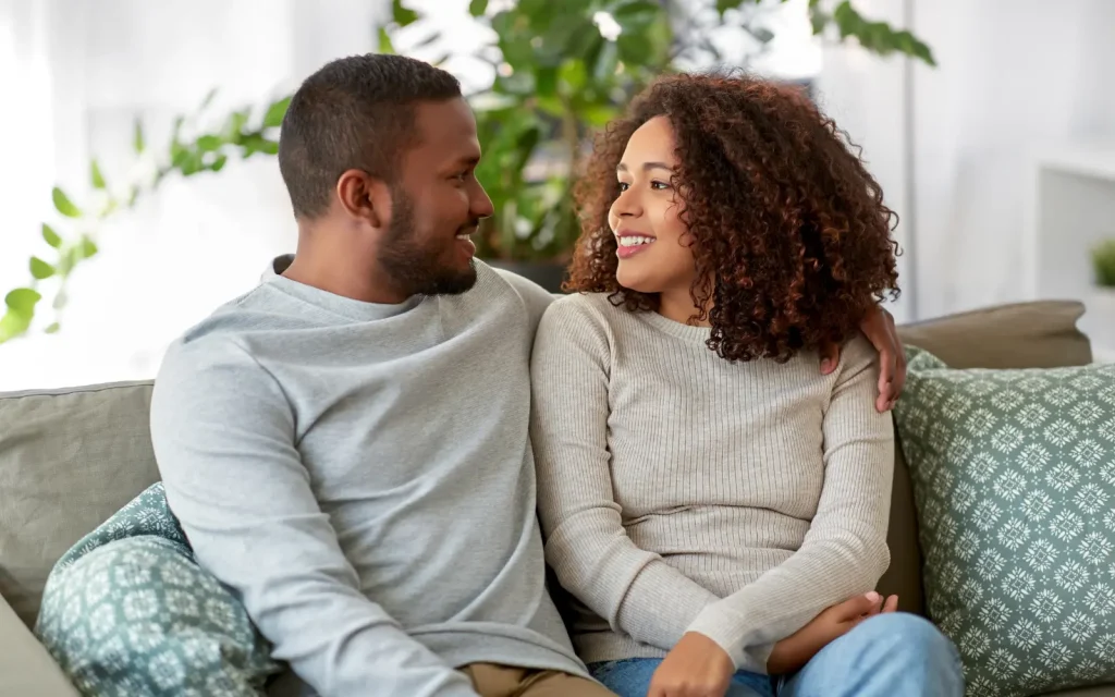 A couple having an intimate conversation cuddling on a couch during a temporary break from therapy.