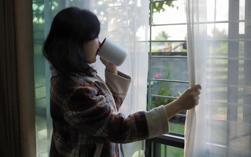 ADHD-woman-couples-therapy A woman looking pensively out of a window, representing ADHD couples therapy