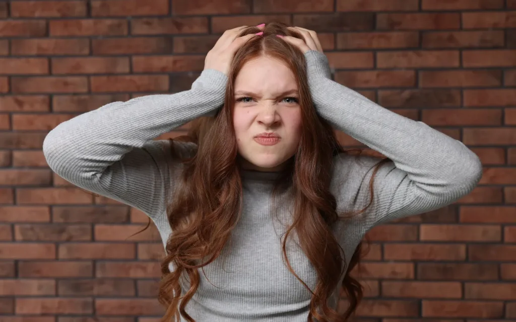 Emotional-burnout-in-ADHD-relationships-in-couples-therapy A woman with her head in her hands, representing emotional burnout in ADHD relationships