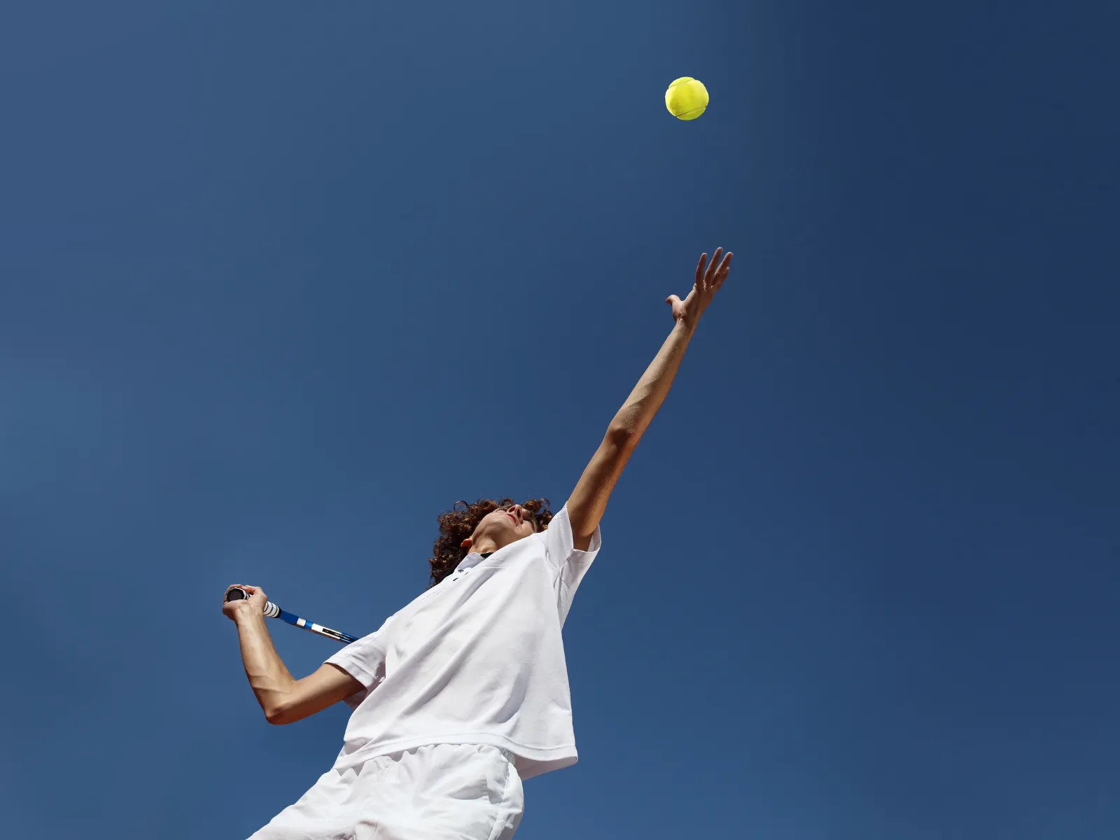 A tennis player mid-serve