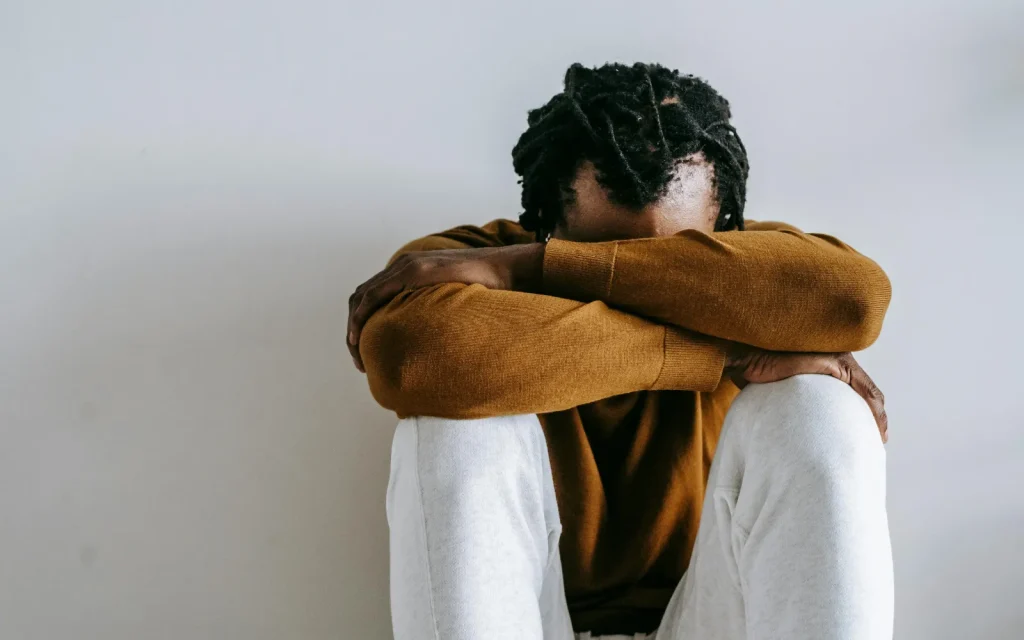 A man with his head in his hands, representing anxiety that causes paralysis in men