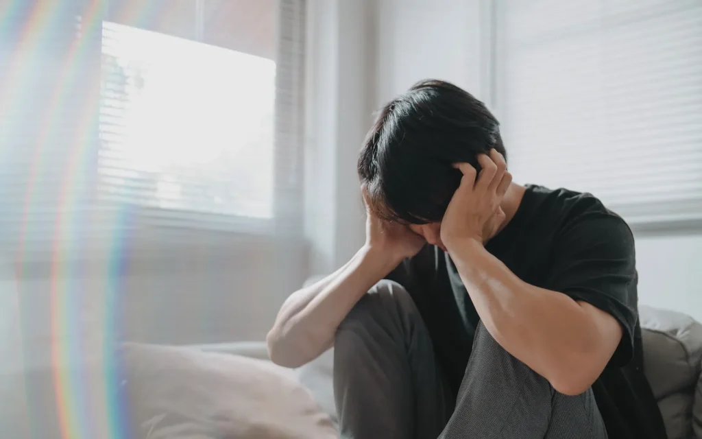 A man holding his head, representing headaches caused by anxiety